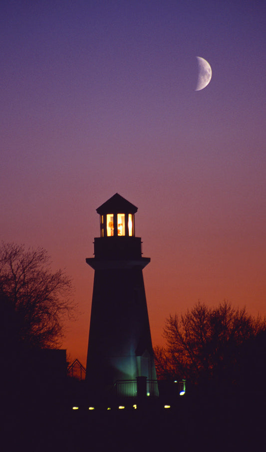 Silhouette of a Lighthouse with Moon in the Sky